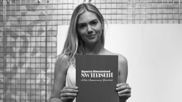 Kate Upton poses with SI Swimsuit 60th anniversary yearbook. 