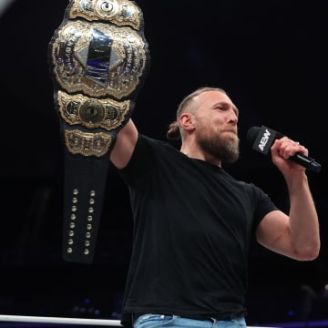 Bryan Danielson holding up his newly won AEW World title