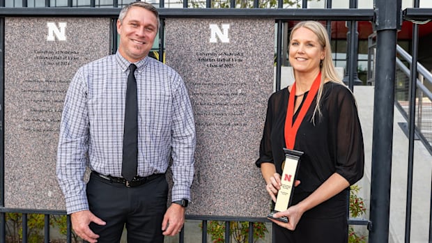 Lisa Reitsma Rautenberg stands with her husband, Rick, after the NU Athletics Hall of Fame induction. 