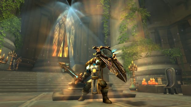 World of Warcraft protection paladin raises his shield in the air.