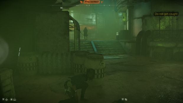 Star Wars Outlaws gameplay: Kay crouching behind some barrells and crates, looking up a small staircase with two armed guards