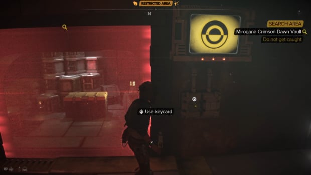 Kay in front of a small chamber blocked by a red barrier with a prompt to use a keycard.