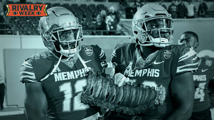 Memphis' Cormontae Hamilton (12) and Patrick Lucas Jr. (50) carry the “Battle for the Bones” rib trophy after Memphis defeated UAB 53-18 at Simmons Bank Liberty Stadium in Memphis, Tenn., on Saturday, November 16, 2024.