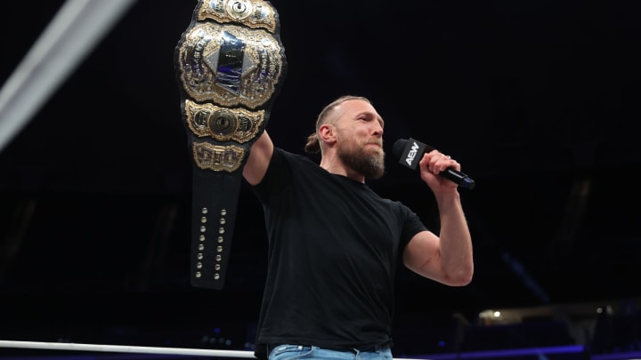 Bryan Danielson holding up his newly won AEW World title