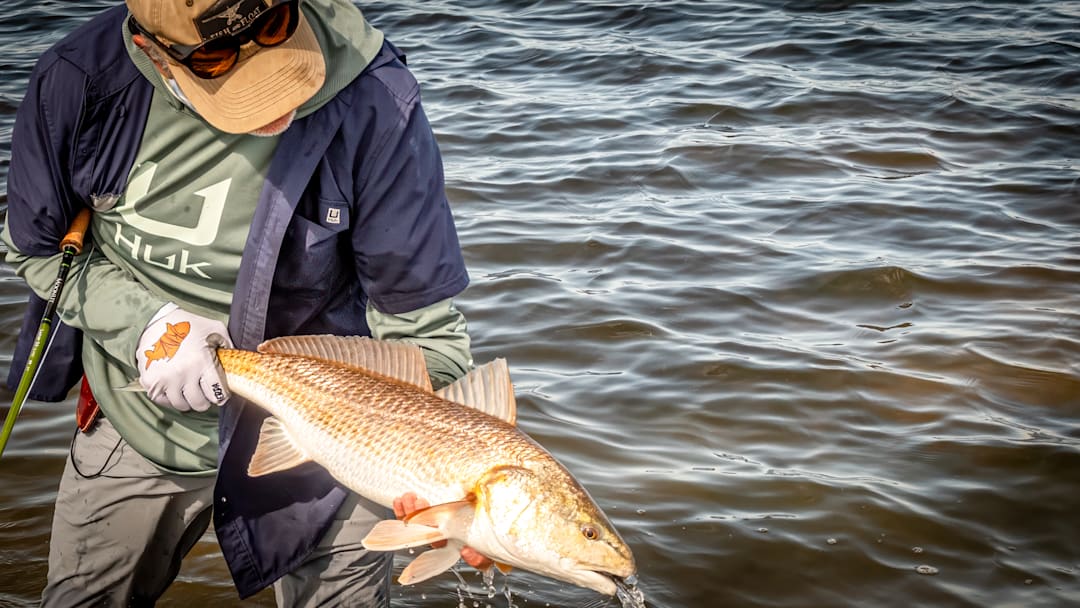 Keeping myself protected from the sun with HUK technical fishing shirt and hoodie - Fly fishing for redfish in Melbourne, Florida - Fly rod: The Moonlit Fiberglass 8-weight.