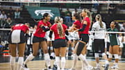 Nebraska volleyball players celebrate a point at Michigan State. The Huskers played in front of a then record crowd in 2023 and are expected to set a new attendance mark this weekend at the Breslin Center.