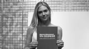 Kate Upton poses with SI Swimsuit 60th anniversary yearbook. 