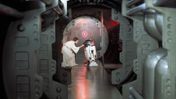 Princess Leia (Carrie Fisher) loads the plans for the Death Star battle station with a plea for help to Obi-Wan Kenobi into R2-D2 on the Rebel Blockade Runner.
