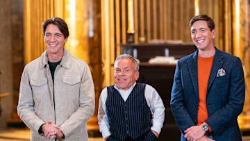 Hosts James Phelps and Oliver Phelps with guest judge Warwick Davis, as seen on Harry Potter: Wizards of Baking, Season 1.