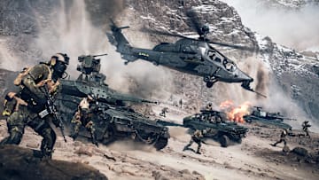 Battlefield 6 screenshot of infantry and vehicles charging over a dusty battlefield.