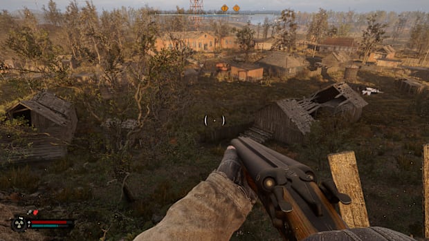 Stalker 2 screenshot looking down on a ruined town from atop a cliff.