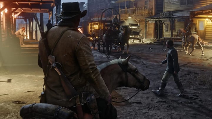 Arthur Morgan rides into the town of Valentine as people walk by in Red Dead Redemption 2