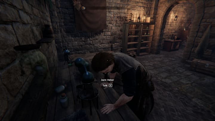 Jann Haber bending over his desk in Tainted Grail