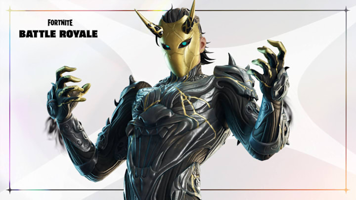 A man in twisted black armour with a gold mask covering his whole face.