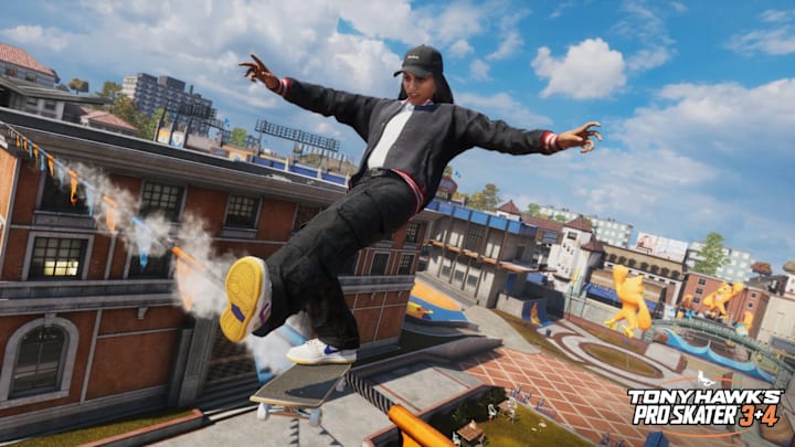 A person on a skateboard, grinding across a wre holding up bunting between buildings.