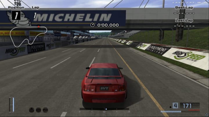 A red car driving along a racetrack.