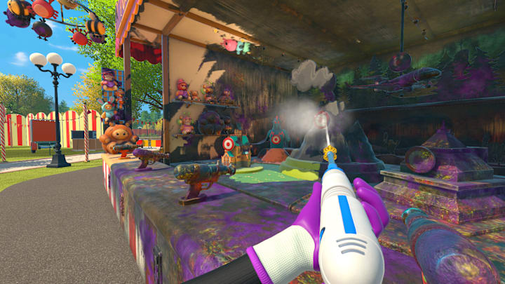 Spraying a dirty carnival game stall with a powerwasher.