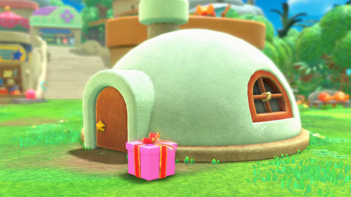 A pink present in front of Kirby's round house in Kirby and the Forgotten Land. 