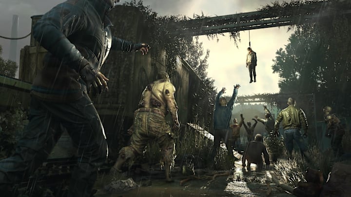 Zombies walking through a street, reaching up for a corpse hanging from above.