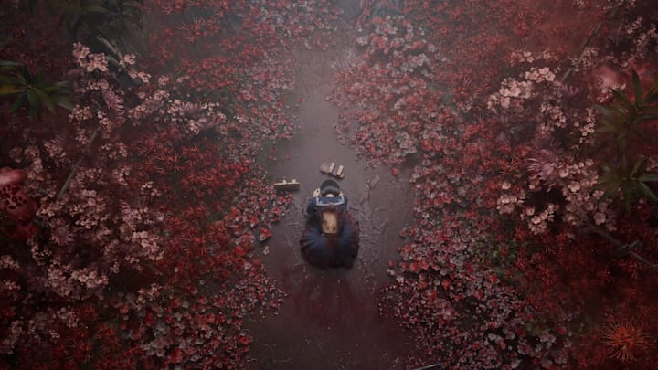 A school girl with blood on her clothes kneeling down in a field of red flowers and roots.