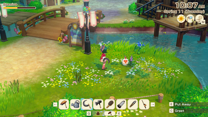 A chicken sitting in some flowers by a stream.