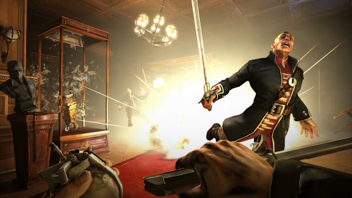 Men fly as an explosion fills a room and a chandelier swings in Dishonored