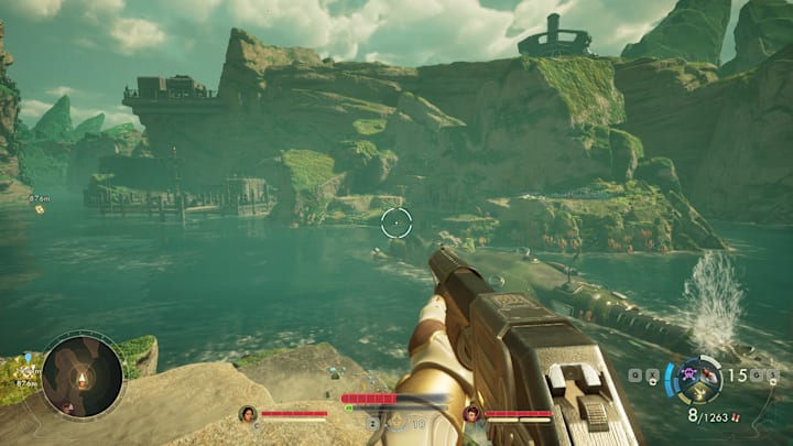 A sunken ship in a river next to some cliffs.