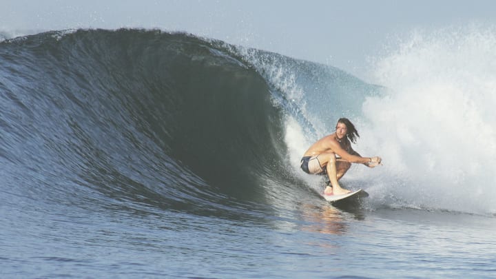 Crouching surfer in action