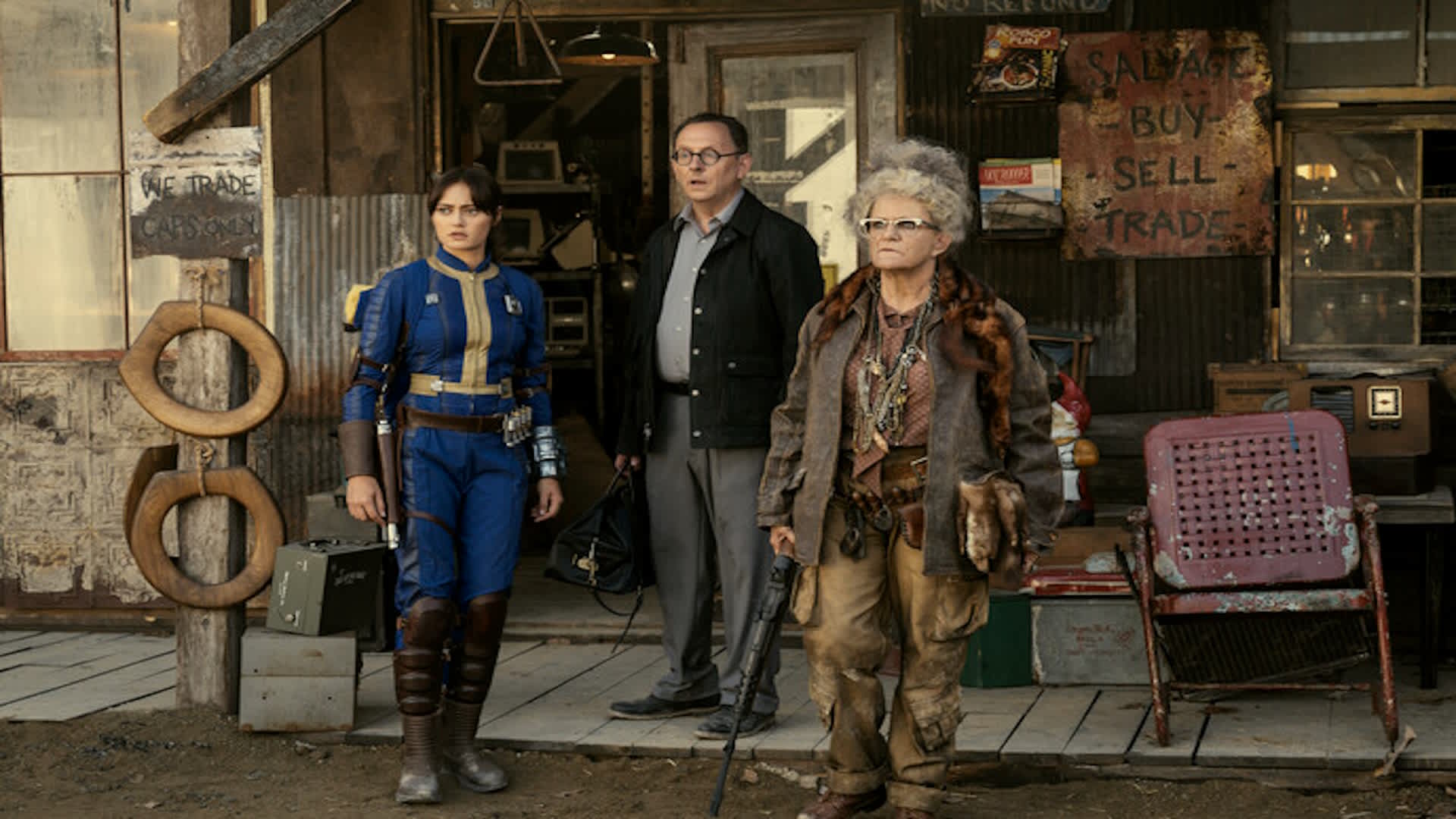 Fallout's Lucy, Dr. Wilson, and Ma June, standing outside a ramshackle building