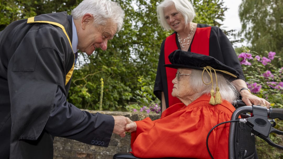 Rosemary Fowler (seated) receives her doctorate from Sir Paul Nurse, chancellor of the University of Bristol, at a ceremony at Darwin College, Cambridge, UK.