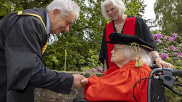 Rosemary Fowler (seated) receives her doctorate from Sir Paul Nurse, chancellor of the University of Bristol, at a ceremony at Darwin College, Cambridge, UK.