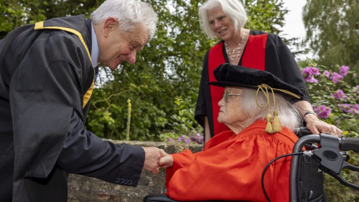 Rosemary Fowler (seated) receives her doctorate from Sir Paul Nurse, chancellor of the University of Bristol, at a ceremony at Darwin College, Cambridge, UK.