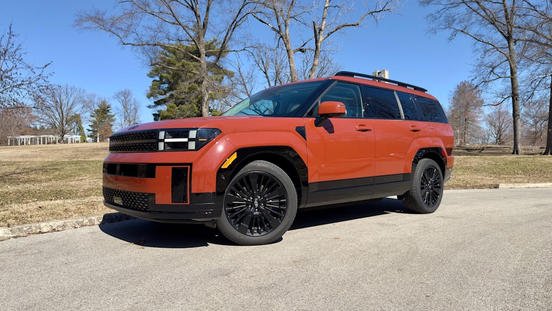A three quarter shot of a 2025 Hyundai Santa Fe Hybrid Calligraphy AWD in Terracotta Orange paint.