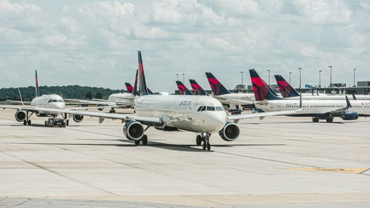 A group of Delta airplanes on the ground