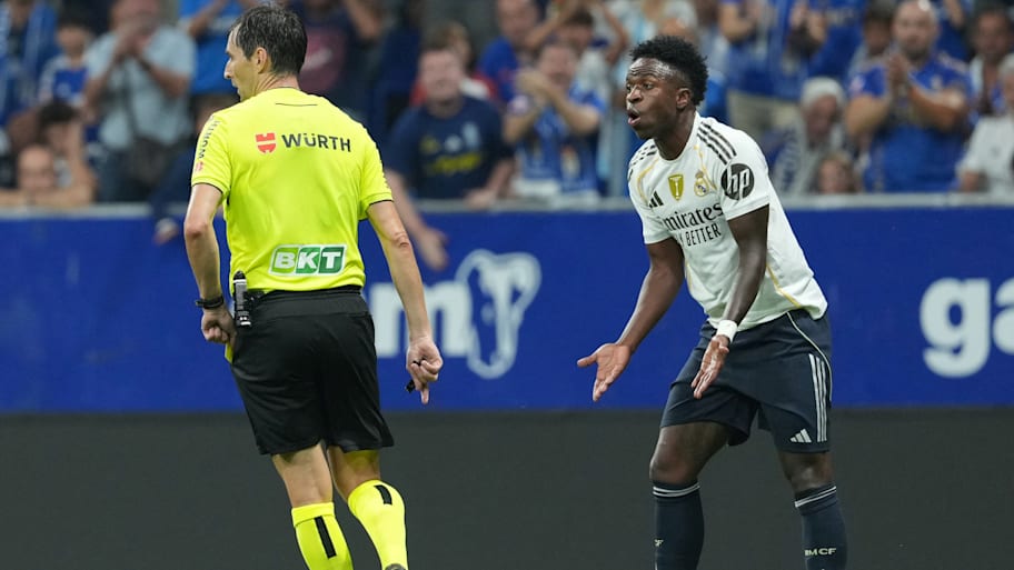 Vinicius Junior (right) talking to a referee.