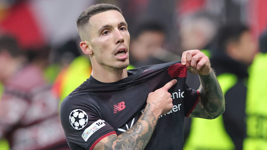 Alejandro Grimaldo pointing to his badge.