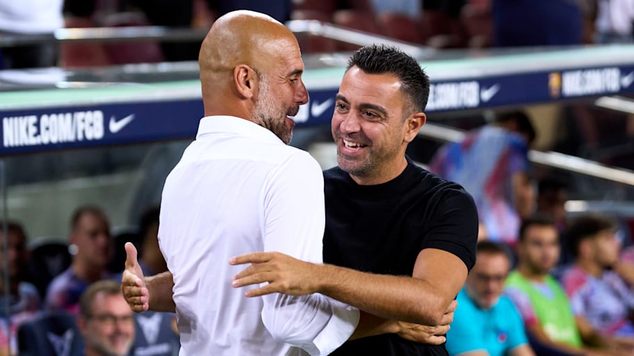 Xavi (right) hugging Pep Guardiola.