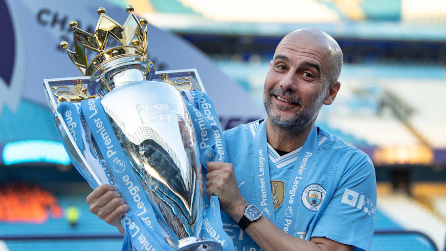 Pep Guardiola holding the Premier League trophy.