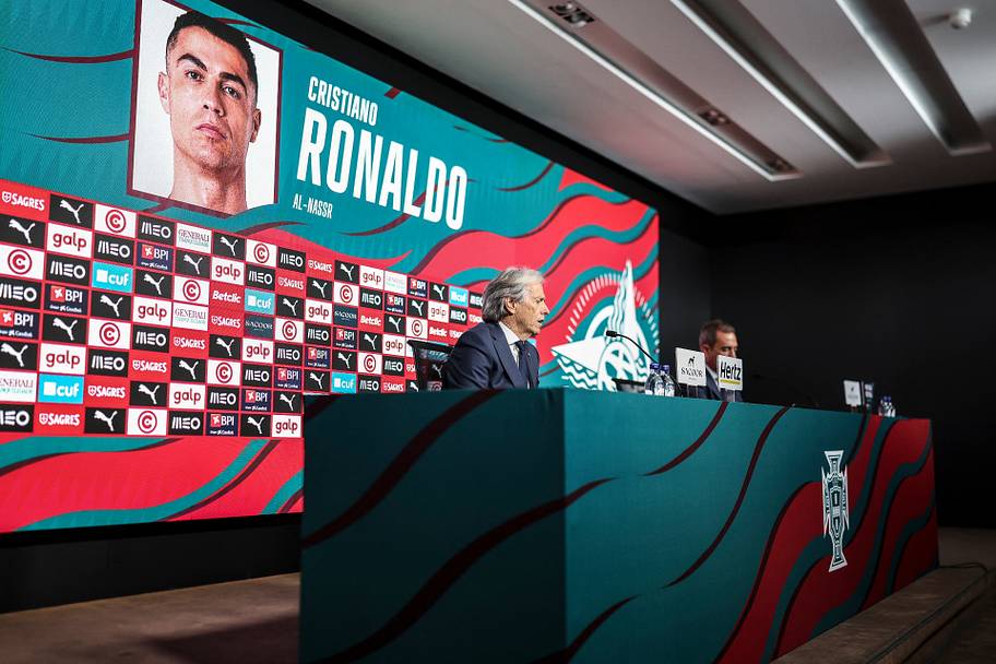 Jorge Jesus at a desk in front of a picture of Cristiano Ronaldo.