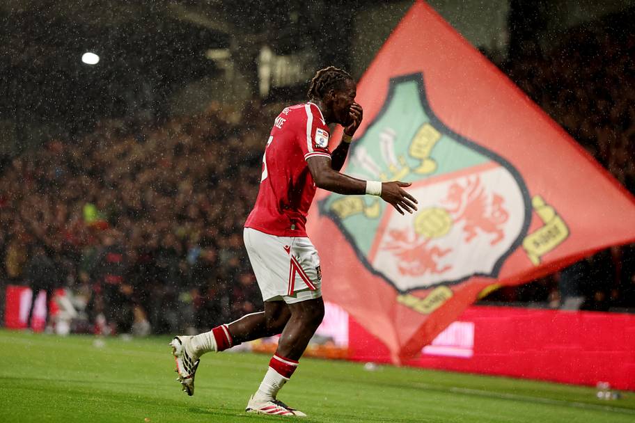 Jacques Ekomié running in front of a flag.