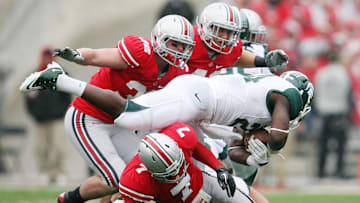 Ohio State Buckeyes Travis Howard (7) Storm Klein (32) and Andrew Sweat (42) team up to stop Michigan State Spartans running back Le'Veon Bell (24) in the first quarter of their NCAA football game at Ohio Stadium, October 1, 2011.