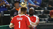 Great Britain catcher Harry Ford (1) is given a kings crown and robe by teammate Chavez Young after hitting a solo home run against Colombia in the seventh inning during the World Baseball Classic at Chase Field in 2023.