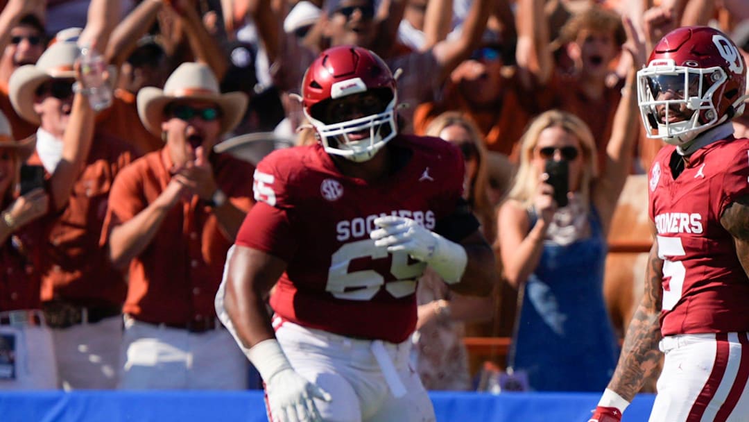 Texas fans celebrate behind Oklahoma Sooners defensive lineman Jayden Jackson (65) and defensive back Woodi Washington (5) after a Texas touchdown during the Red River Rivalry college football game between the University of Oklahoma Sooners (OU) and the Texas Longhorns at the Cotton Bowl in Dallas, Saturday, Oct. 12, 2024. Texas one 34-3.