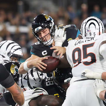 Dec 4, 2023; Jacksonville, Florida, USA;  Jacksonville Jaguars quarterback Trevor Lawrence (16) reaches out to score a touchdown against the Cincinnati Bengals in the third quarter at EverBank Stadium. Mandatory Credit: Nathan Ray Seebeck-Imagn Images