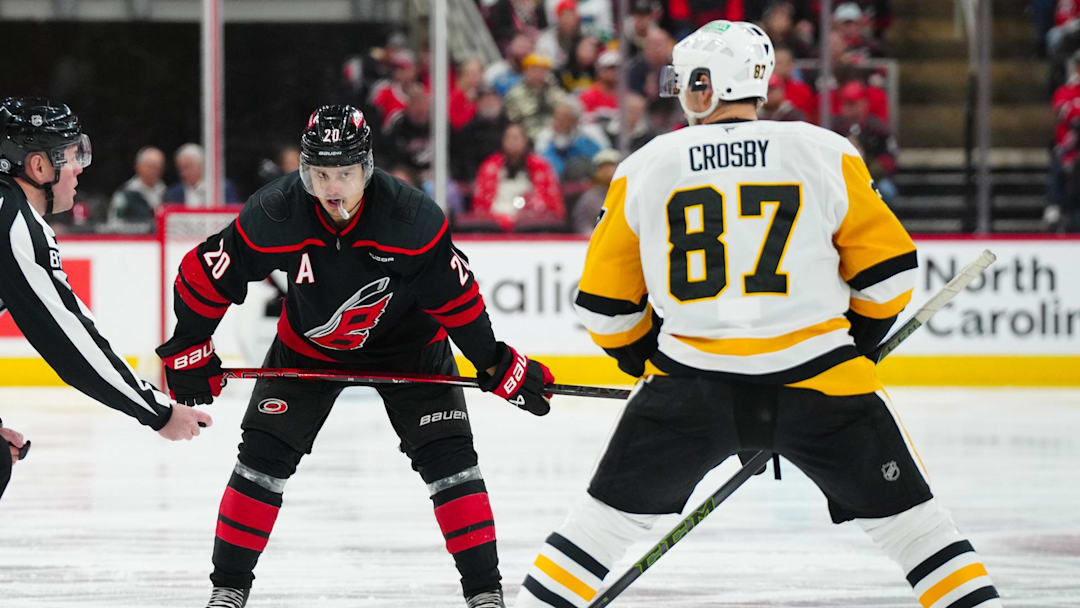 Jan 5, 2025; Raleigh, North Carolina, USA;  Carolina Hurricanes center Sebastian Aho (20) gets ready to take a face off against Pittsburgh Penguins center Sidney Crosby (87) during the third period at Lenovo Center. Mandatory Credit: James Guillory-Imagn Images