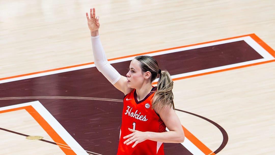 Carleigh Wenzel lifts her hand in celebration as she transitions back to defense after a three point basket.