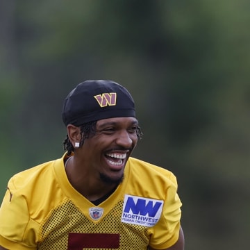 Jul 26, 2024; Ashburn, VA, USA; Washington Commanders quarterback Jayden Daniels (5) jokes during warmup before day three of training camp at Commanders Park. Mandatory Credit: Geoff Burke-USA TODAY Sports