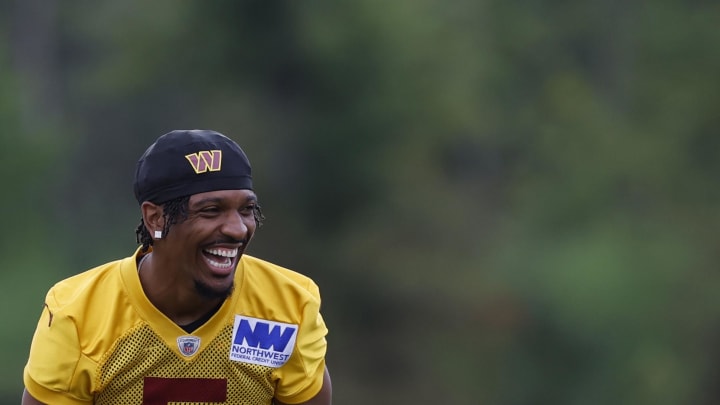 Jul 26, 2024; Ashburn, VA, USA; Washington Commanders quarterback Jayden Daniels (5) jokes during warmup before day three of training camp at Commanders Park. Mandatory Credit: Geoff Burke-USA TODAY Sports