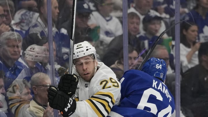 Apr 24, 2024; Toronto, Ontario, CAN; Toronto Maple Leafs forward David Kampf (64) checks Boston Bruins defenseman Parker Wotherspoon (29) into the boards during the first period of game three of the first round of the 2024 Stanley Cup Playoffs at Scotiabank Arena. Mandatory Credit: John E. Sokolowski-USA TODAY Sports