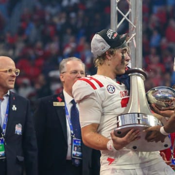 Dec 30, 2023; Atlanta, GA, USA; Mississippi Rebels quarterback Jaxson Dart (2) holds the Peach Bowl trophy as wide receiver Tre Harris (9) catches the top after a victory against the Penn State Nittany Lions at Mercedes-Benz Stadium. Mandatory Credit: Brett Davis-USA TODAY Sports